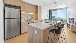 A modern kitchen with a built-in island, stainless steel appliances, and a city view. - River&Ocean View Luxury 2BD Apt amazing Location (Broadbeach)