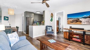 Una sala de estar moderna con sofá, mesa de centro y mueble para televisión.