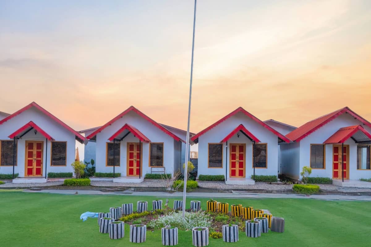 A row of identical buildings with red roofs and white walls, arranged in a symmetrical pattern.