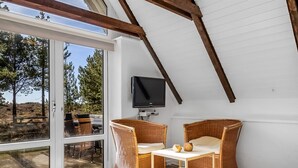 A cozy room with a TV, wicker chairs, and a table. - "Ilona" - 2km from the sea by Interhome (Rømø)