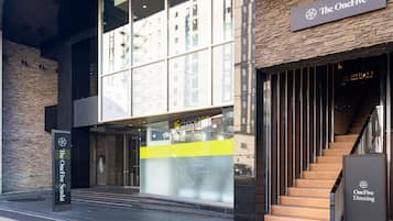A modern building with a sign for "The OneFive Dining" and a visible entrance with a glass facade.
