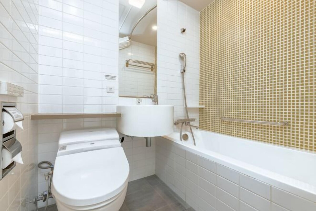 A modern bathroom with a toilet, sink, and bathtub.