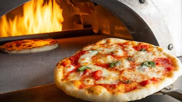 Un horno de pizza con dos pizzas en cocción.