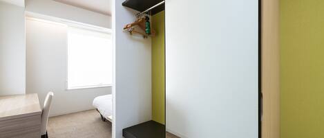 A modern, compact room with a desk, a bed, and a built-in bench.
