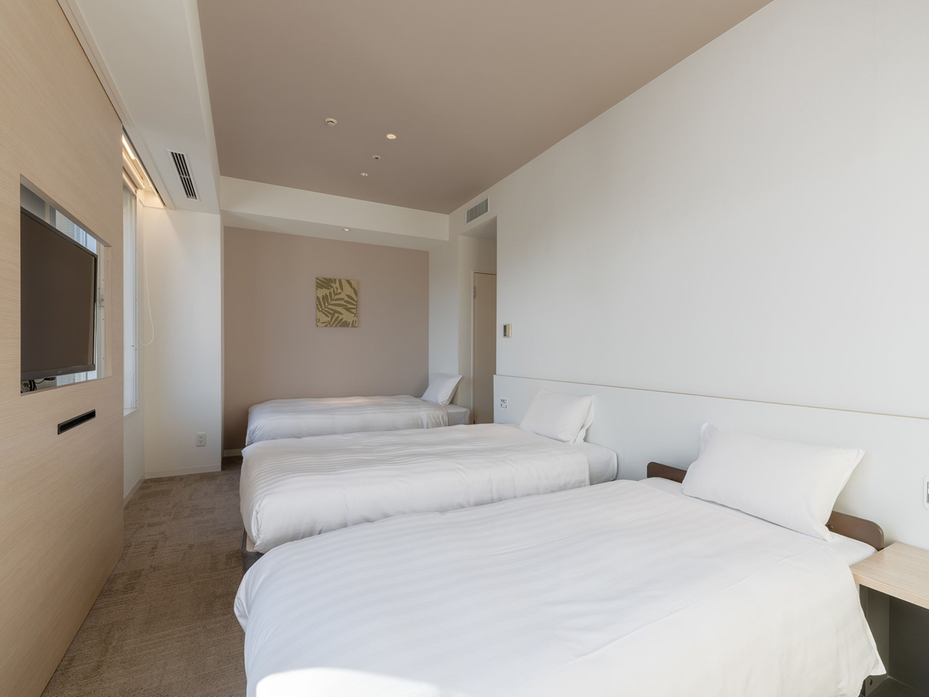 Quarto de hotel com duas camas, uma janela e uma obra de arte na parede.