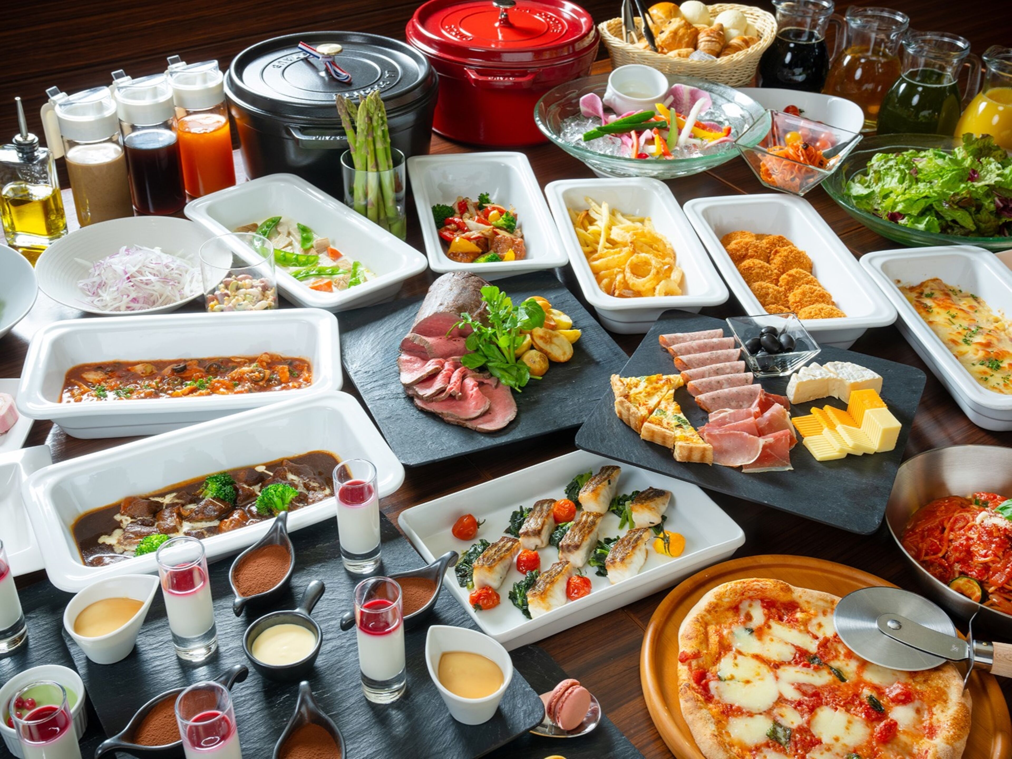 Une variété d’aliments et d’assaisonnements disposés sur une table, notamment des viandes, des fromages et des légumes.