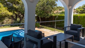 A covered outdoor seating area with a pool, surrounded by greenery and a view of the countryside. - Villas Finesse Type 1 by Interhome (Son Bou)