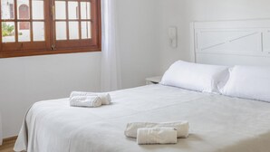 A neatly made bed with white linens and two rolled towels on the bed. - Son Bou Gardens 3 dorm by Interhome (Son Bou)