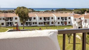 A coastal hotel with white buildings, red-tiled roofs, and a view of the sea.