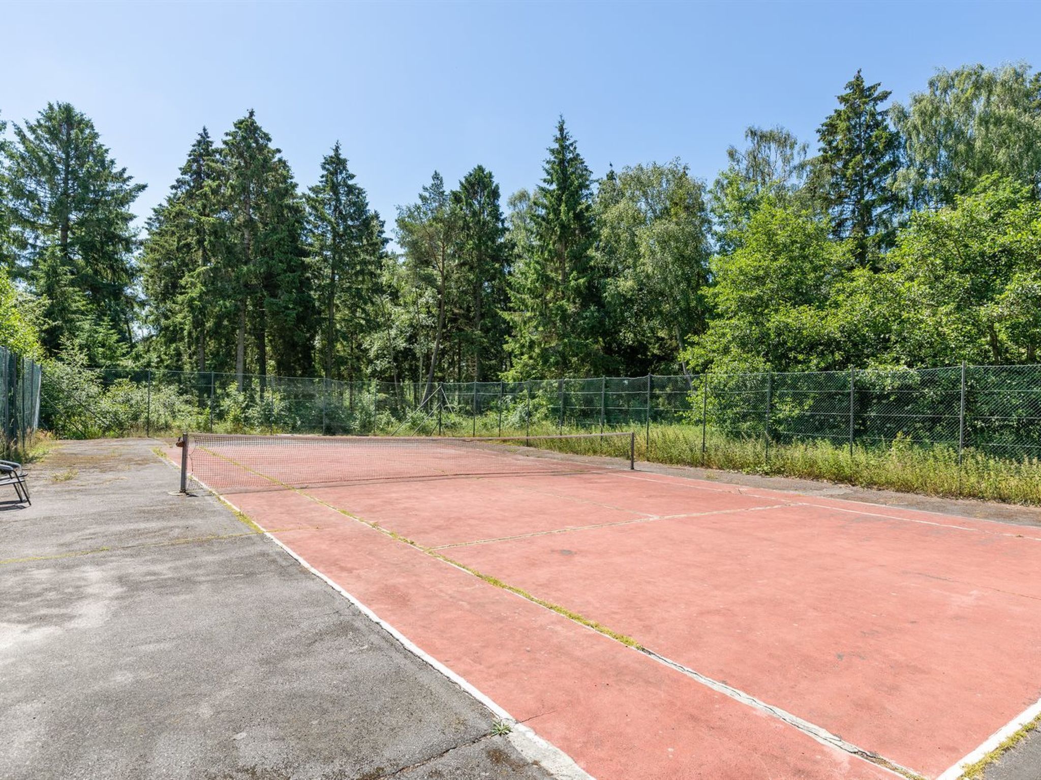 A tennis court surrounded by trees.