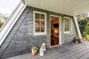 A house with a sloped roof, a door leading to an interior, and a small porch with a potted plant and a decorative lantern. - Holiday Home 'Elbliebe' with Private Terrace, Wi-Fi and Air Conditioning (Dannenberg)