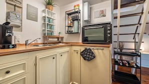 A kitchen with a microwave, coffee maker, and a shelf with kitchenware. - Holiday Home 'Elbliebe' with Private Terrace, Wi-Fi and Air Conditioning (Dannenberg)