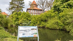 A historic building with a tower, surrounded by lush greenery and a calm water body. - Holiday Home 'Elbliebe' with Private Terrace, Wi-Fi and Air Conditioning (Dannenberg)