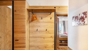 A room with wooden panel walls, a pull-out bed, a wooden ceiling, and a painting on the wall. - Holiday Apartment "Elena" with Mountain View, Shared Terrace & Wi-Fi (See)