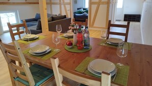 A dining area with a wooden table set for two, chairs, and a view of a living room. - Apartment 'Kleine Auszeit 1' with Private Terrace and Wi-Fi (Forst)