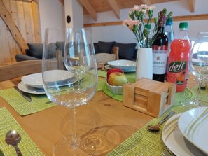 A dining table with wine glasses, plates, and a bottle of Deitel fruit drink. - Apartment 'Kleine Auszeit 2' with Private Terrace and Wi-Fi (Forst)