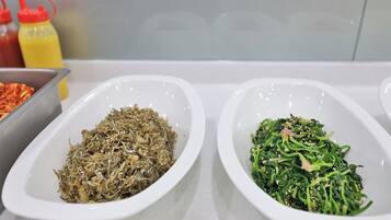 Two white oval dishes containing different food items on a kitchen counter.