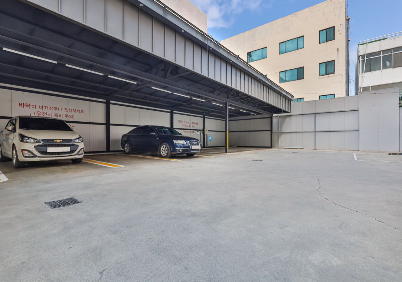 A parking garage with two cars parked under a covered area.