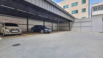 A parking garage with two cars parked under a covered area.