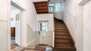 A staircase with a wooden handrail leading to a landing.