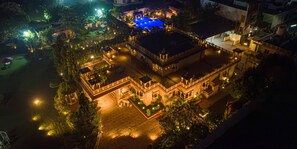 An aerial view of a historic building with a courtyard, illuminated by ambient lighting. -  ama Stays & Trails Adbhut Mahal, Jaipur (Jaipur)