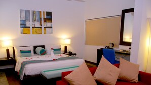Ein Hotelzimmer mit einem Bett, einem roten Sofa, einem Schreibtisch und einem großen Spiegel.