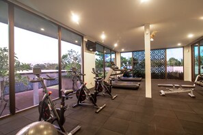 A gym with stationary bikes, treadmills, and weight machines. - Tridi Beach Villa by Nagisa Bali (Tabanan)