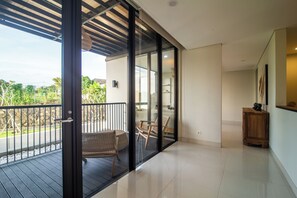 Una habitación moderna con balcón, una banca de madera y una mesita.