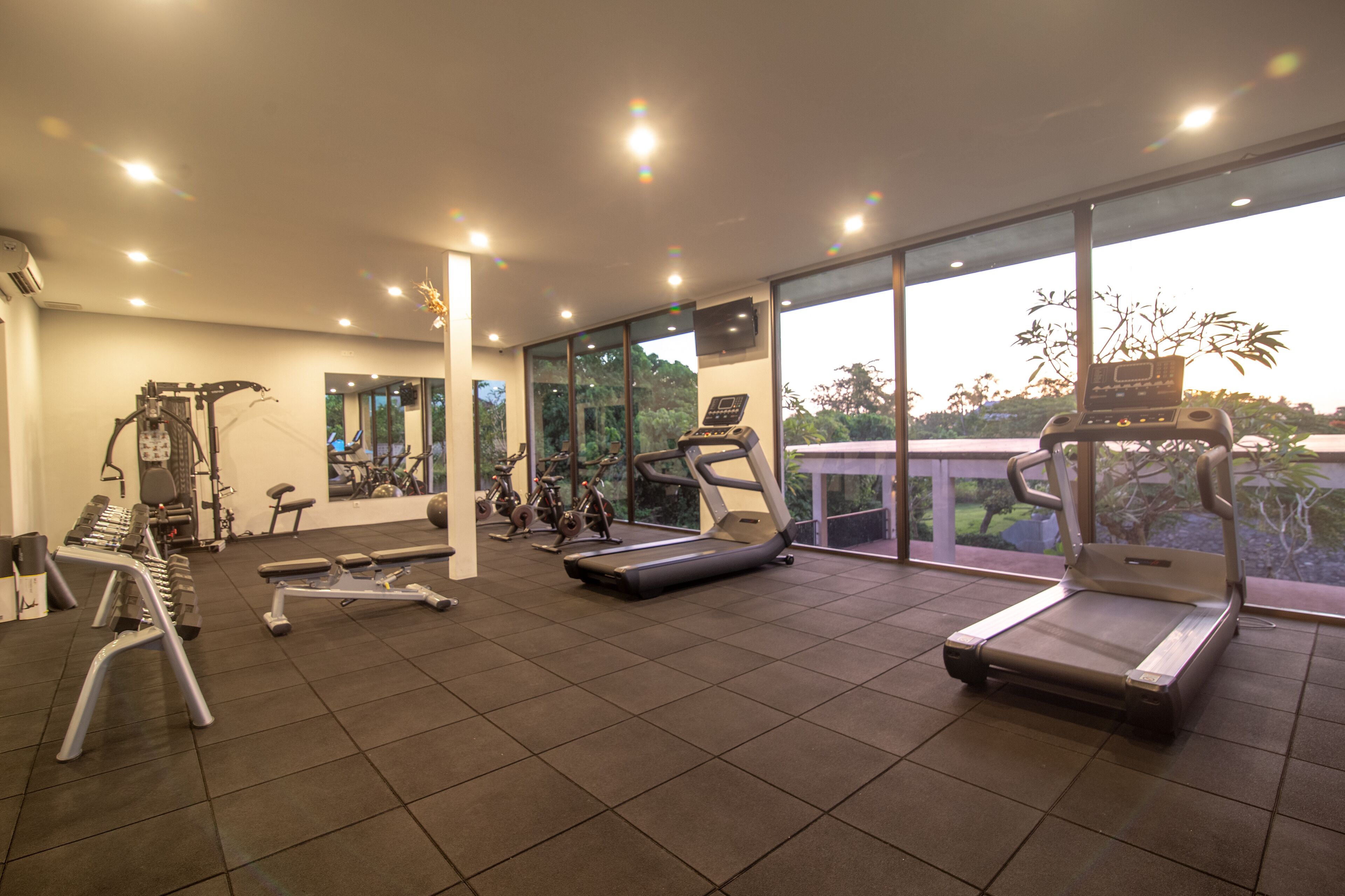 A gym with treadmills, elliptical machines, and weightlifting equipment.