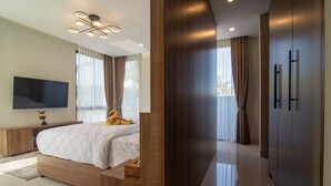 Una camera da letto moderna con un letto grande, una TV a schermo piatto e un'armadiatura in legno.