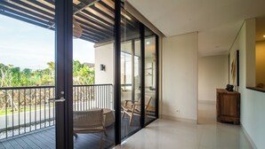 Una camera moderna con un balcone, una panca in legno e un tavolino.