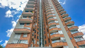 A high-rise building with a central staircase, multiple balconies, and a glass entrance. - Luxury Duplex, Poblado Gem!
 (Medellín)