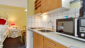 A compact kitchen with wooden cabinets, a stainless steel sink, and a microwave. - "Gunhild" - 22km from the sea by Interhome (Bredebro)