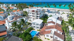 A coastal resort with multiple-story buildings, a swimming pool, and a beach view.