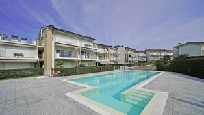 A swimming pool surrounded by multi-story residential buildings with balconies. - La Castellana Relax in Sirmione (Sirmione)