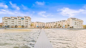 Et hotel ved stranden med en lang bro, der fører til bygningen.