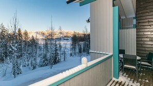 Un balcón con vistas a un bosque nevado.