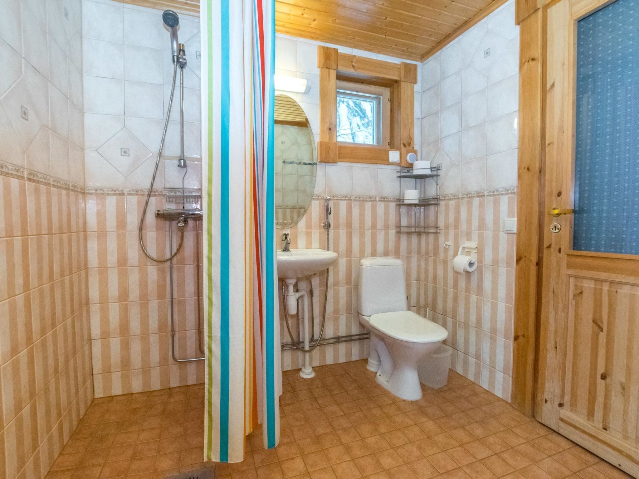 Une salle de bain avec douche, toilettes et lavabo.