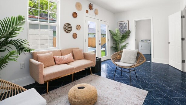 Ein Wohnzimmer mit Sofa, Sessel, Teppich und Wanddekoration.