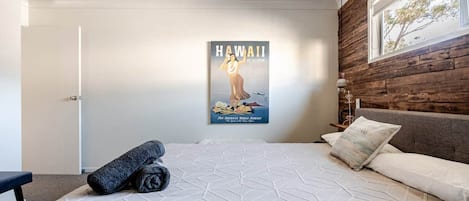 A bedroom with a bed, a poster on the wall, and a window.