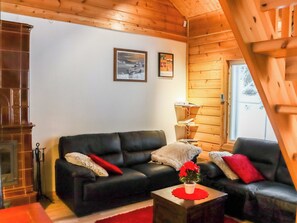 Un salon chaleureux avec une cheminée, un canapé, une table basse et deux tableaux encadrés au mur.