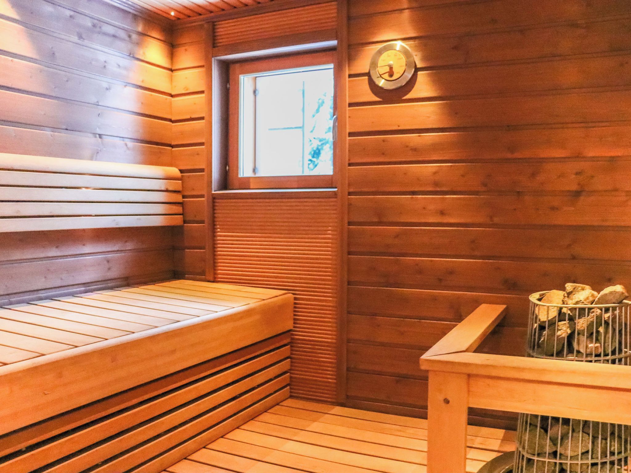 Un sauna avec des bancs en bois et une fenêtre.