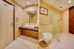 A bathroom with a marble sink, a glass-enclosed shower, and a toilet. - City Mark Hotel (Gurugram)