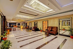 A spacious lobby with a marble floor, leather seating, and a large chandelier. - City Mark Hotel (Gurugram)