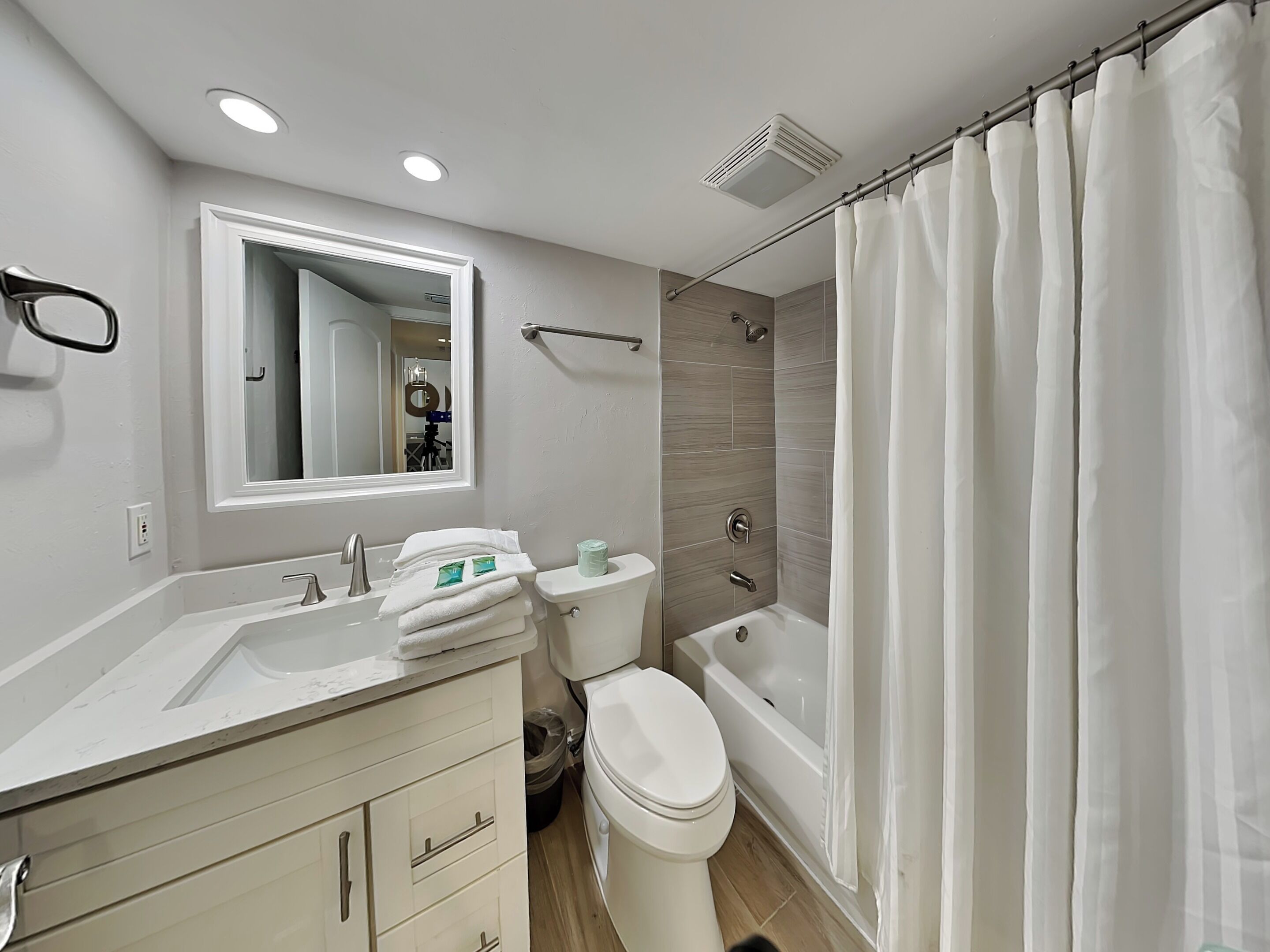 A modern bathroom with a sink, toilet, and bathtub.
