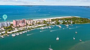An aerial view of a coastal area with a marina, buildings, and boats. - Estero Island Beach Villas by Distinctive Beach Rentals (Fort Myers Beach)