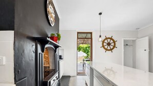 Eine moderne Küche mit Einbauherd, einer Uhr und einem Blumentopf auf der Arbeitsfläche.
