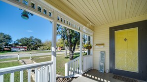 A porch with a yellow door, white railings, and a welcome sign. - Pet-Friendly Brady Vacation Home Near Wineries! (Brady)