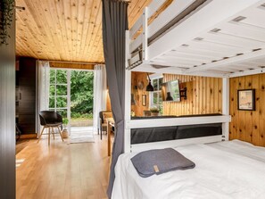 A bunk bed room with a wooden ceiling, a desk, a chair, and a window overlooking greenery. - "Imma" -  from the sea by Interhome (Hals)