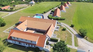 A large property with multiple buildings, a swimming pool, and a view of the sea.
